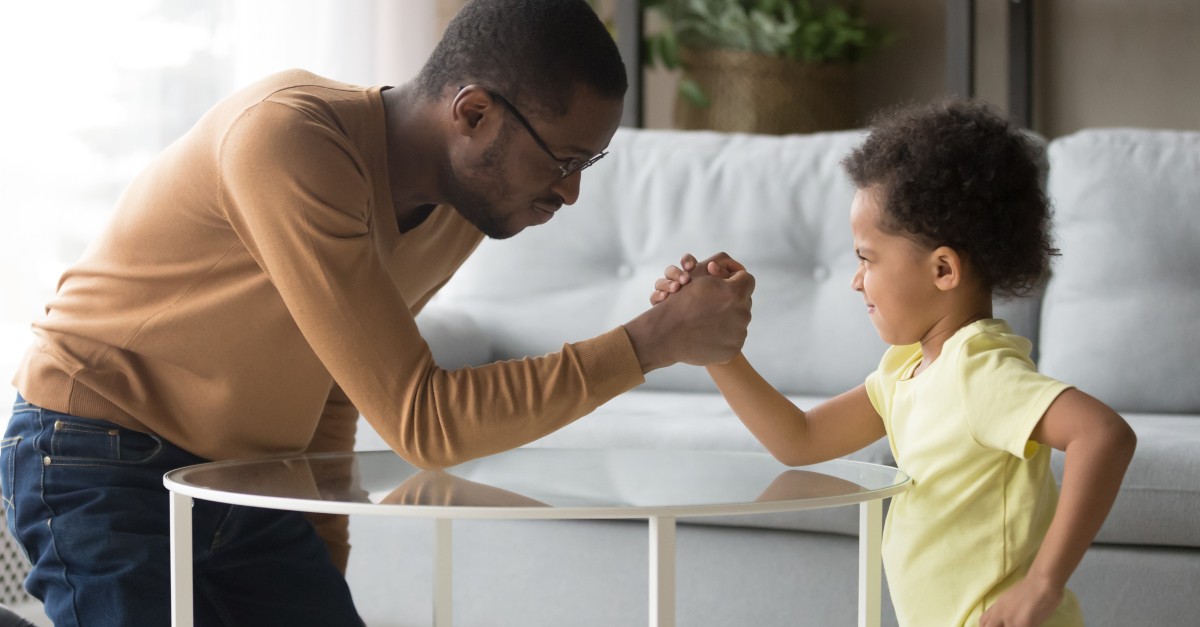 young son arm wrestling dad