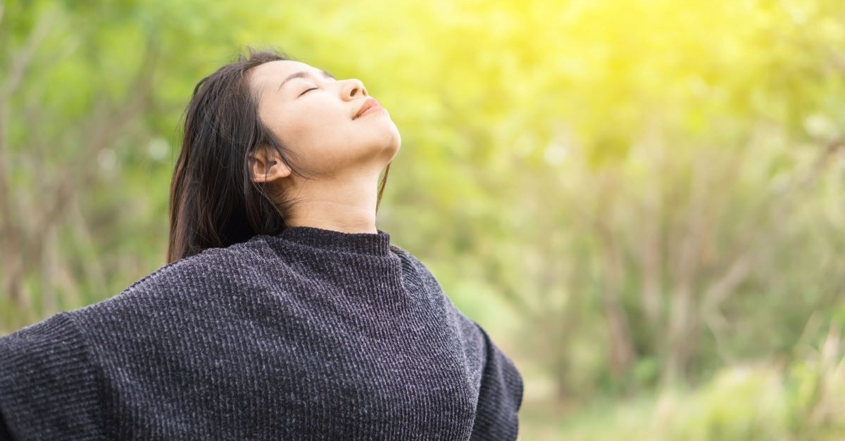 woman eyes closed facing sky, how wonder can help you break free from fear