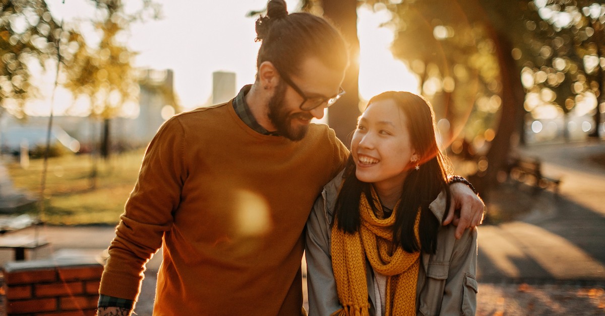 Happy couple laughing together walking in the fall