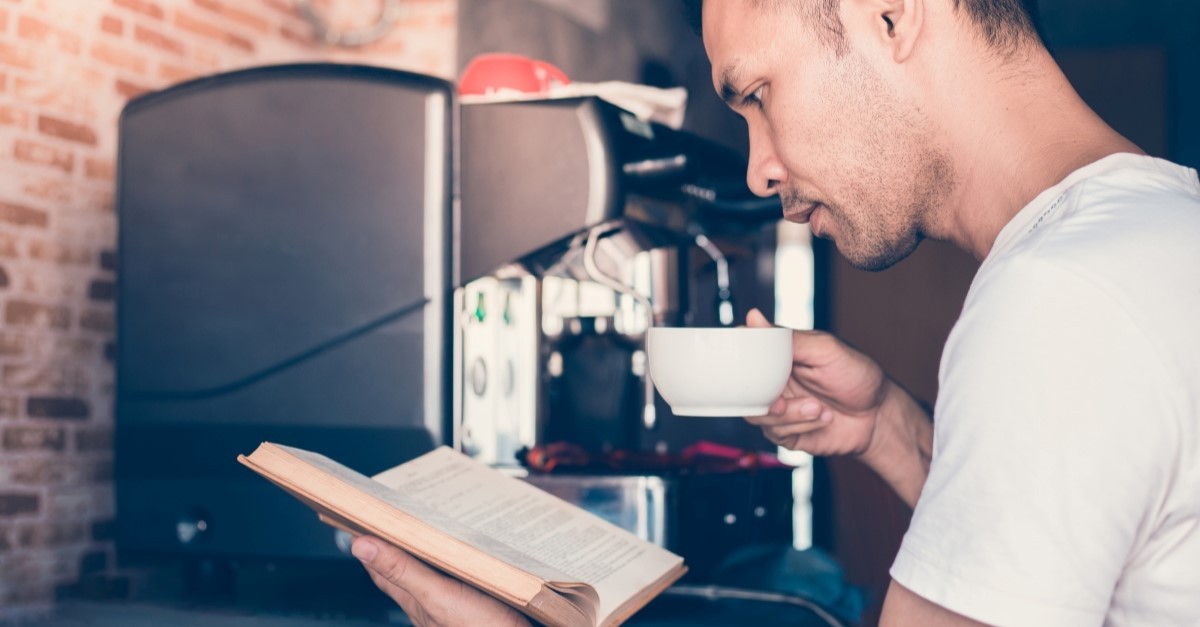 man reading bible as he gets coffee from a machine, outdated church traditions that need to go