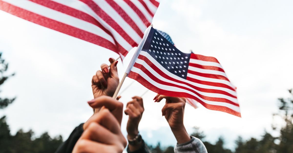 People holding American flags; can we love both God and country?